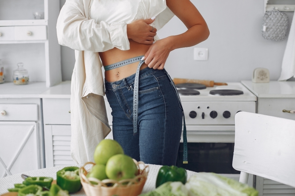 Beautiful and sporty woman in a kitchen with vegetables on keto diet