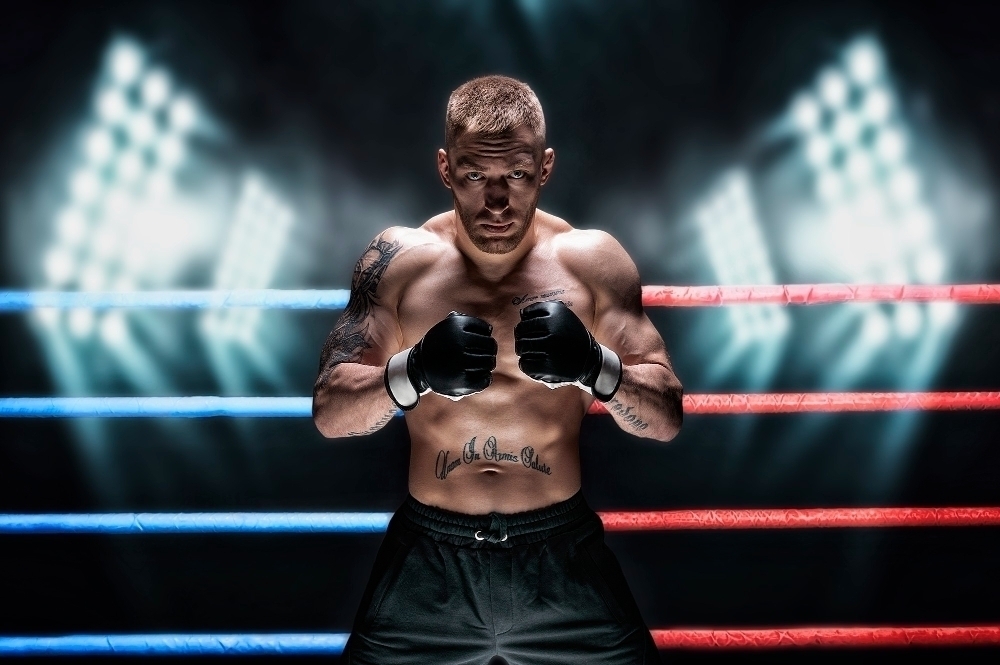 Mixed martial artist posing in the ring against spotlights. Concept of mma ufc thai boxing classic boxing. Mixed media
