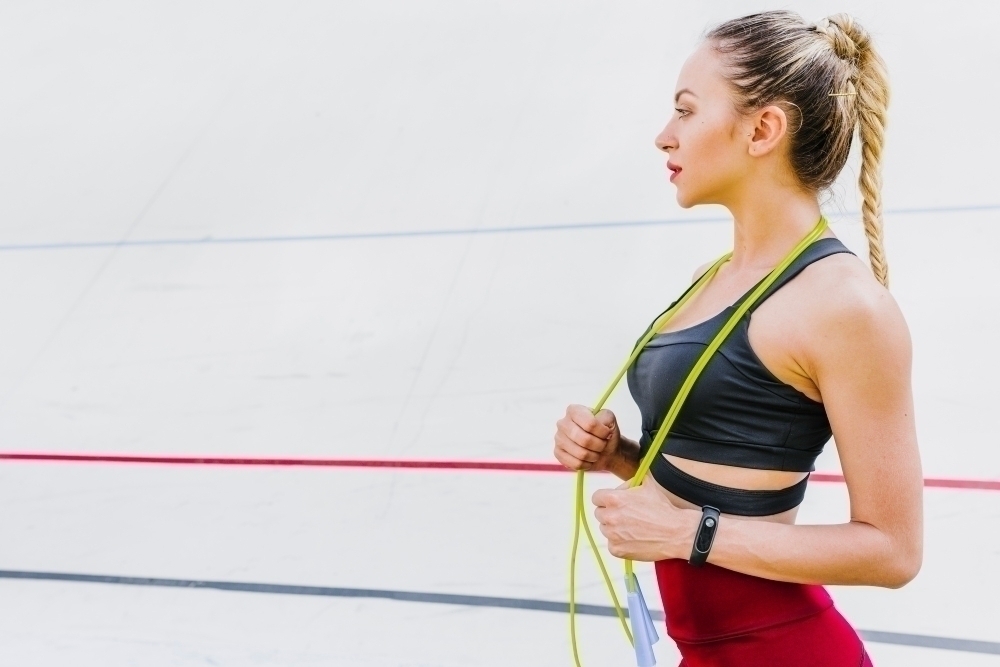 Side view of woman with jump rope