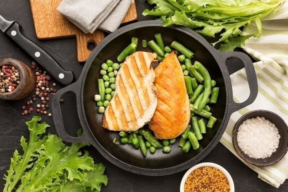 Top view grilled chicken and peas in pan with condiments