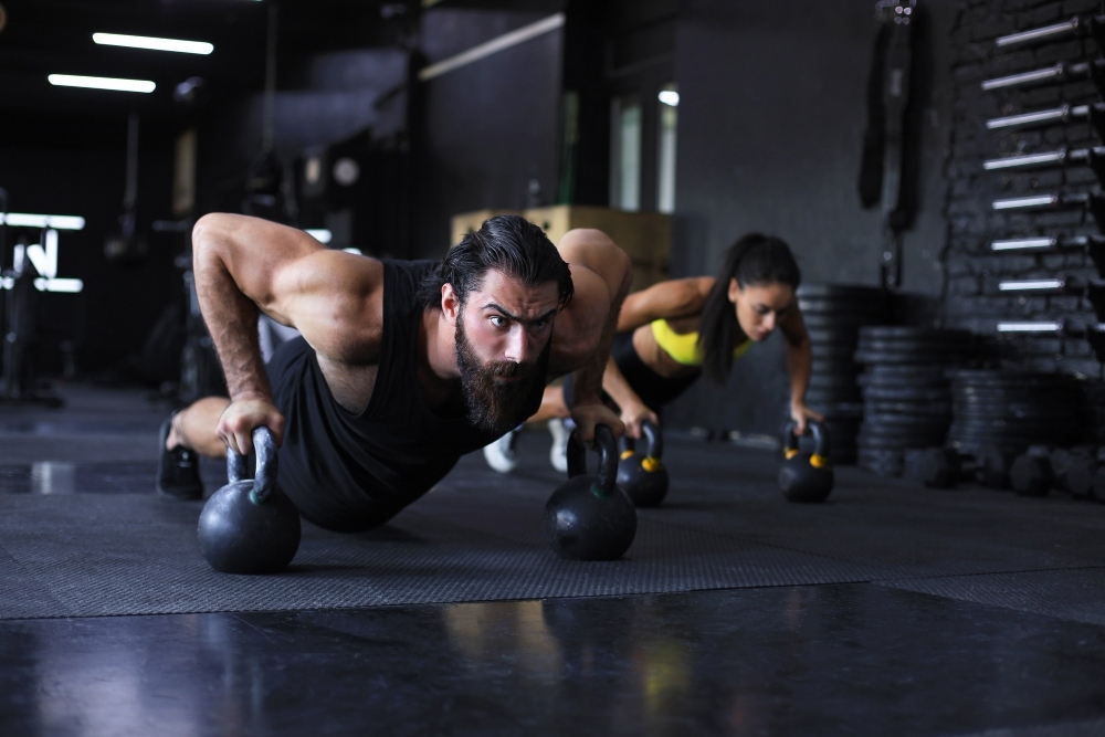 man-och-kvinna-gor-armhavningar-pa-gym