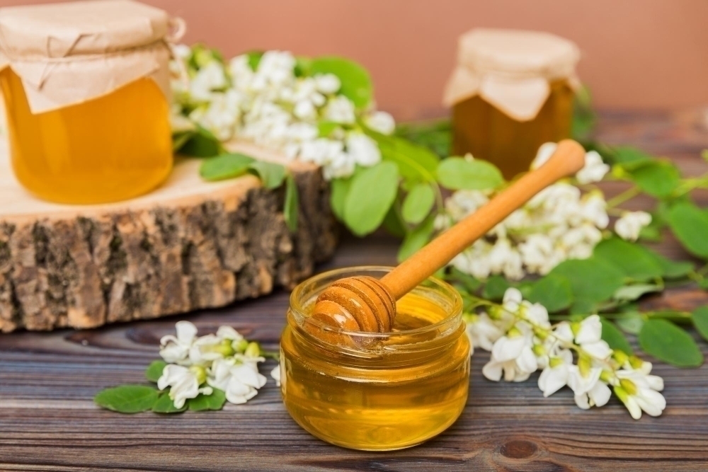 sweet-honey-jar-surrounded-spring-acacia-blossoms-honey-flows-from-spoon-jar-jars-clear-fresh-acacia-honey-wooden-background
