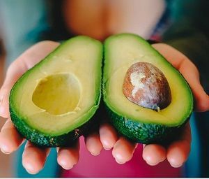 kvinde holder avocado